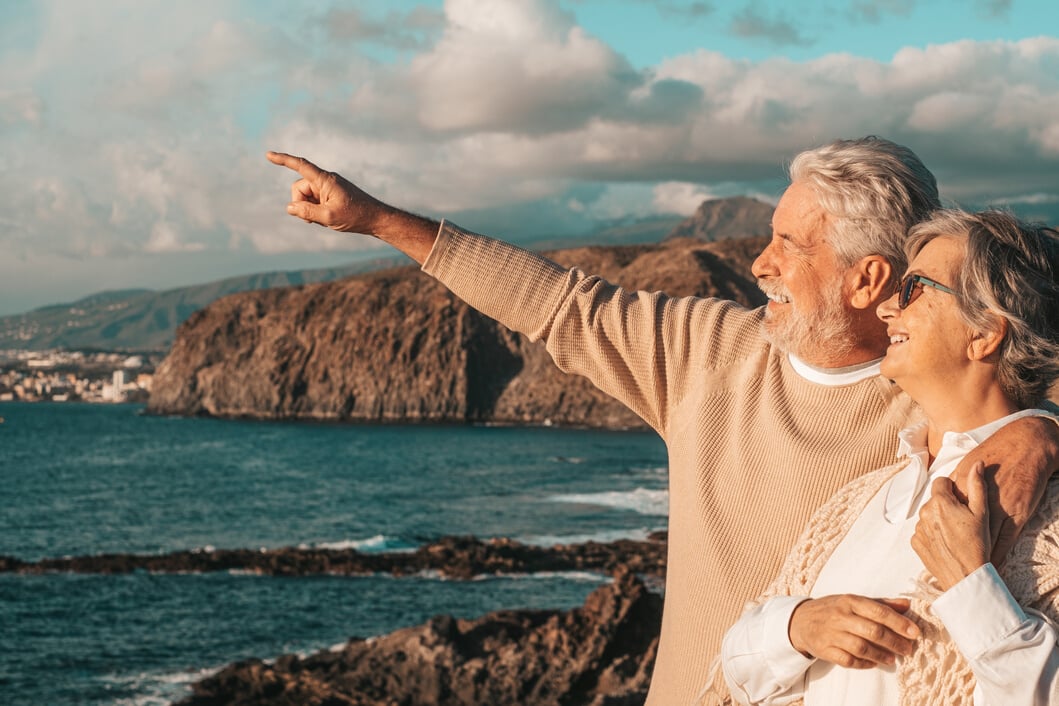 Elderly Couple Pointing by the Sea